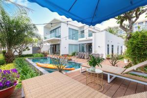 un patio extérieur avec une piscine et un bâtiment dans l'établissement Aria Vũng Tàu - Blue Sapphire Resort Căn Hộ, Biệt Thự Nghỉ Dưỡng Cách Biển 50m, à Xã Thắng Nhứt