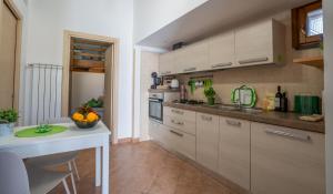 a kitchen with white cabinets and a table in it at La Casa di Teo Sorrento Coast in Sant'Agnello