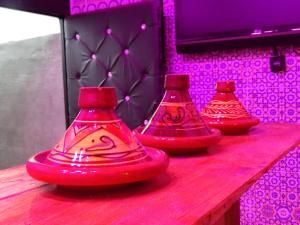 three red vases sitting on top of a wooden table at Youth housing EL HABIB in Fès