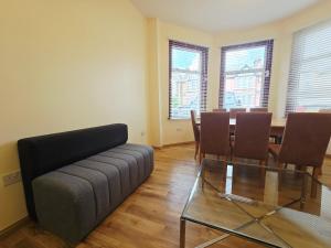 イルフォードにあるLondon Luxury 3 bedroom flat, free parking, garden, sleeps x10, Close to Tubeのソファとテーブルと椅子のあるリビングルーム