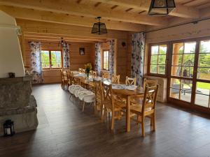 a dining room with a long table and chairs at Mecenasówka Noclegi in Zawoja