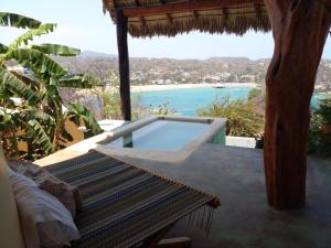 a resort with a swimming pool and a bench at Angelita's Nest House in Puerto Ángel