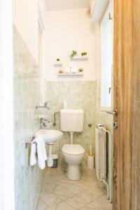 a bathroom with a white toilet and a sink at The Loft in Koper
