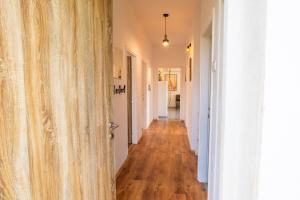 a hallway with white walls and wood floors at The Loft in Koper