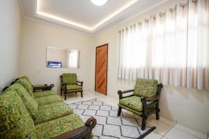 a living room with a couch and two chairs at Casa Serra Negra Área Verde in Serra Negra