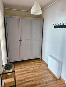 a room with a white cabinet and a wooden floor at Apartament 35 Tuchola in Tuchola