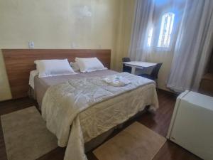 a bedroom with a large bed and a window at Pousada Reino Encantado - São Thomé das Letras - Minas Gerais in São Thomé das Letras