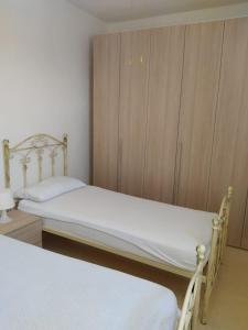 a bedroom with two beds and a wooden cabinet at Villetta a 100 MT dal mare via Nepole Torre Vado in Morciano di Leuca