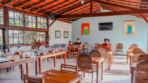 a group of people sitting at tables in a restaurant at Pousada Portal de Paraty- COM GERADOR DE ENERGIA in Paraty