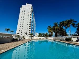 a large swimming pool in front of a tall building at Seaside Serenity in San Juan