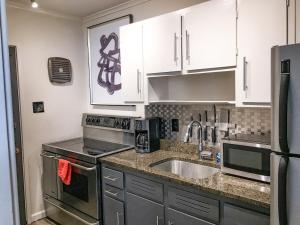 a kitchen with stainless steel appliances and white cabinets at Modern Apartment - Cameron Village in Raleigh