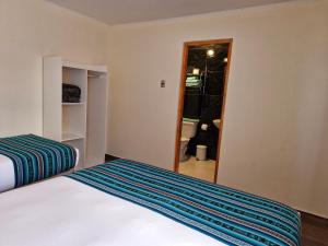 圣佩德罗·德·阿塔卡马hostal casa talitha的有两张床和一面镜子的卧室