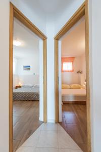 an open door to a bedroom with two beds at Apartment Rita in Preko