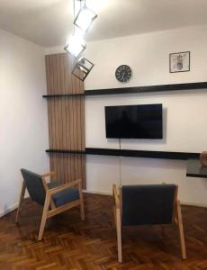 a living room with two chairs and a flat screen tv at Hogar de descanso in Mendoza