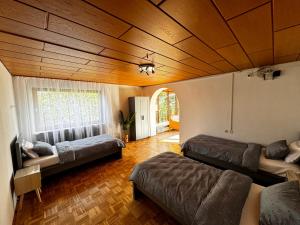 a living room with two beds and a wooden ceiling at Vardi Haus in Ingolstadt