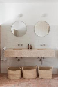 a bathroom with two sinks and two mirrors at Dona Ana House in Tavira +14 photos