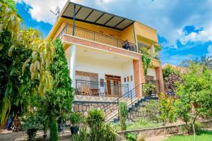 a house with a balcony and trees at Casa tranquila in Kigali