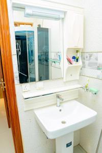 a bathroom with a white sink and a mirror at Casa tranquila in Kigali +12 photos