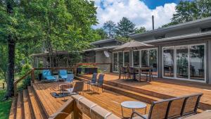 una terrazza in legno con sedie e tavoli su una casa di Longview Cottage - Mountain View, Sunset, Fire Pit a Mentone