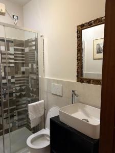 a bathroom with a sink and a toilet and a mirror at Casa dell'Orso Biella in Biella +7 photos