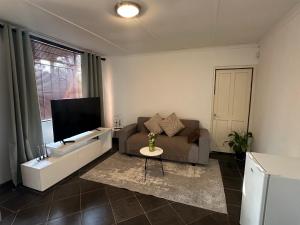 a living room with a couch and a flat screen tv at The Tranquil Ridge in Hilton
