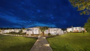 a row of white houses in a yard at night at Mareggio Exclusive Residences & Suites in Gythio