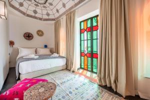 a bedroom with a bed and a stained glass window at Riad LILIA in Marrakech