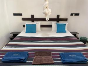 a bedroom with a bed with blue pillows and towels at Yashi's Place Sigiriya in Sigiriya