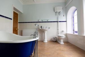 a bathroom with a tub and a toilet and a sink at RAYGILL HOUSE - Spacious Family Retreat in Scenic North Yorkshire in Lothersdale +53 photos