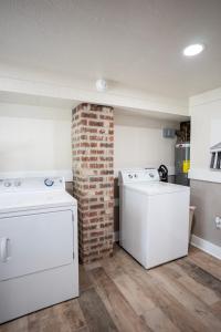 a laundry room with two washers and a brick wall at The Dock House in Mooringsport +74 photos