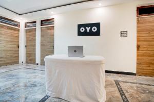 a table with a laptop on top of it in a room at HOTEL O RAJ PALACE in Rāmnagar