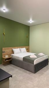 a bedroom with a large bed with a green wall at Terminal 1 in Pʼarakʼar +7 photos