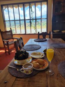 a wooden table with food and a glass of orange juice at Casa Campestre Bimori in Chocontá