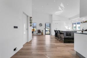 a kitchen and dining room with white walls and wooden floors at The White House in Mosfellsbær