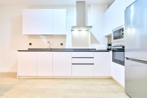 Una cocina blanca con fregadero y refrigerador. en Suite Cañizal 32 Salamanca University Center, en Salamanca 5 fotos más