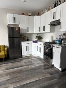 a kitchen with white cabinets and a black refrigerator at Oasis de comodidad Habitación individual o compartida in Jersey City
