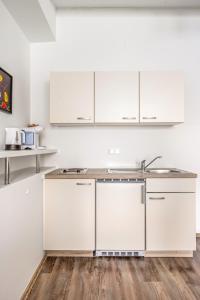 a kitchen with white cabinets and a wooden floor at Beautiful Apartment city center in Vienna +10 photos