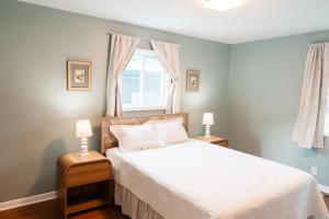 ノックスビルにあるCozy Weekend Retreat for UT Parents in W Knoxvilleのベッド、ナイトスタンド2台、ランプ2個を備えた寝室