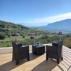 two chairs and a table on a deck with a view at Villa Saint George in Scopello