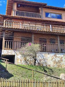 une maison en bois avec une clôture devant elle dans l'établissement Suites da Cla - Suite 1, à Lima Duarte