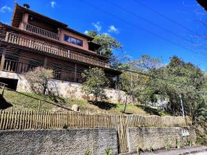 une maison sur une colline avec une clôture dans l'établissement Suites da Cla - Suite 1, à Lima Duarte