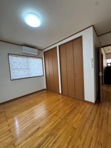 Habitación vacía con suelo de madera y ventana grande. en Amma's House - Vacation STAY 97663v, en Yuwan