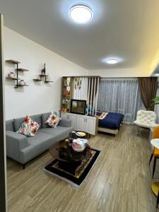 a living room with a couch and a tv at Cosy and chic Cando - vue sur le fleuve Mékong in Phnom Penh +31 photos
