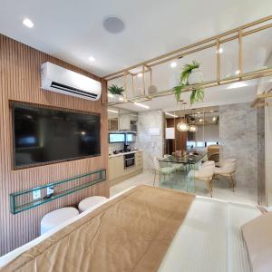 a living room with a tv and a dining room at FLAT LUXO em BOA VIAGEM Prox PRAIA, SHOPPING e AEROPORTO in Recife