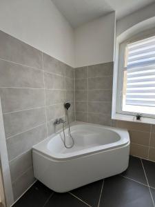 a white bath tub in a bathroom with a window at Berlin flat W 3 separate rooms N0 in Zeitz