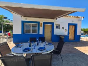 a table with chairs and a blue and white house at Casa rural Bodega Dorada in Cehegín
