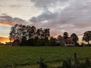 a house in the middle of a field at sunset at Ferienwohnung Seeling Weserbergland in Ottenstein