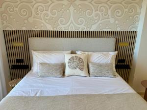a bed with white sheets and pillows in a bedroom at M&M La Cala Suite in La Cala de Mijas