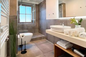 a bathroom with a sink and a toilet and a mirror at Aesten Mare Kühlungsborn Apartment 1 in Kühlungsborn
