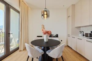 une cuisine et une salle à manger avec une table et des chaises dans l'établissement Boka Place Porto Montenegro-sea view, à Tivat